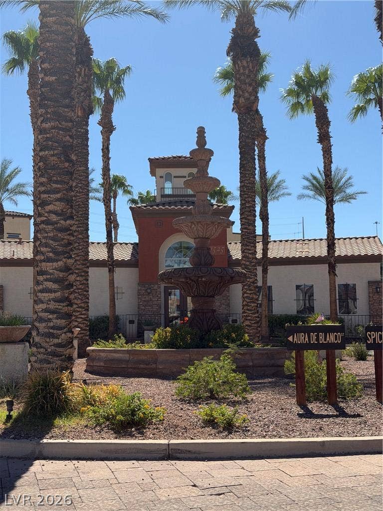 An elegant multi-tiered stone fountain accents the palm-lined driveway welcoming visitors to the property.