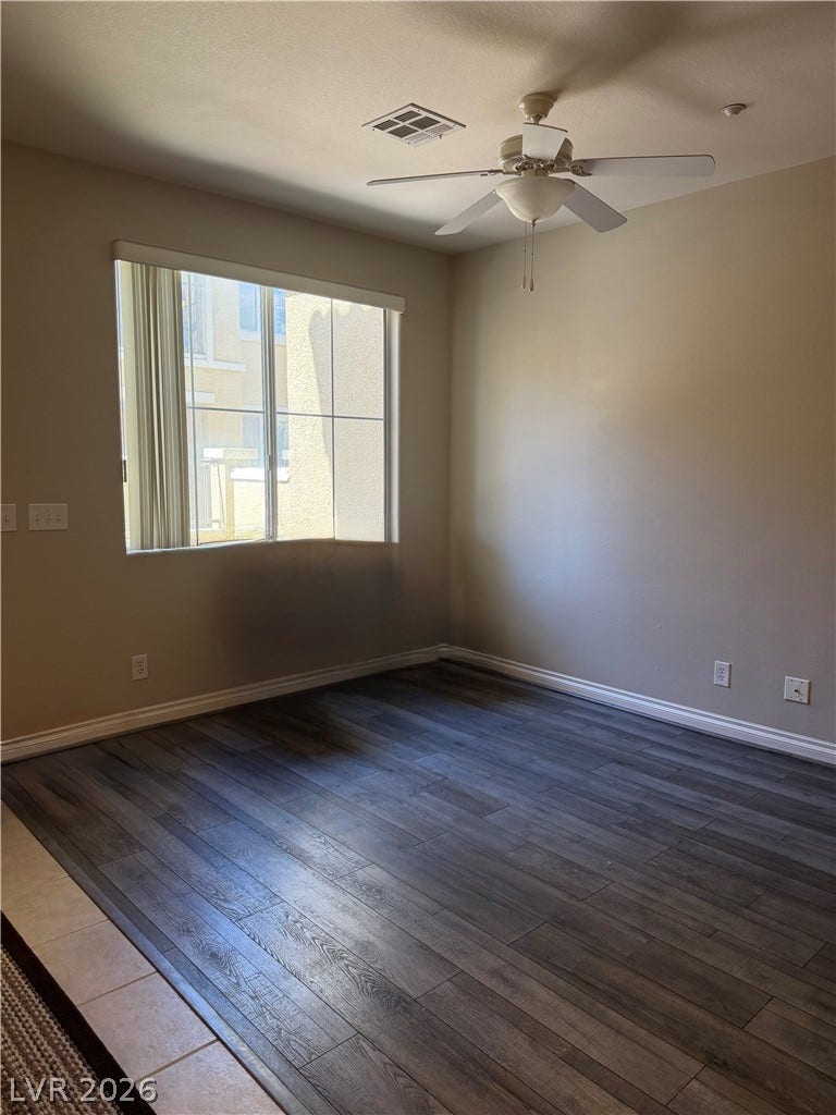 Rich wood-look flooring and a large window define this versatile living space.