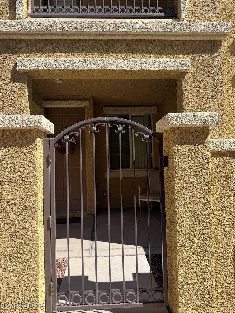 An arched wrought iron gate secures the private stucco courtyard entry.