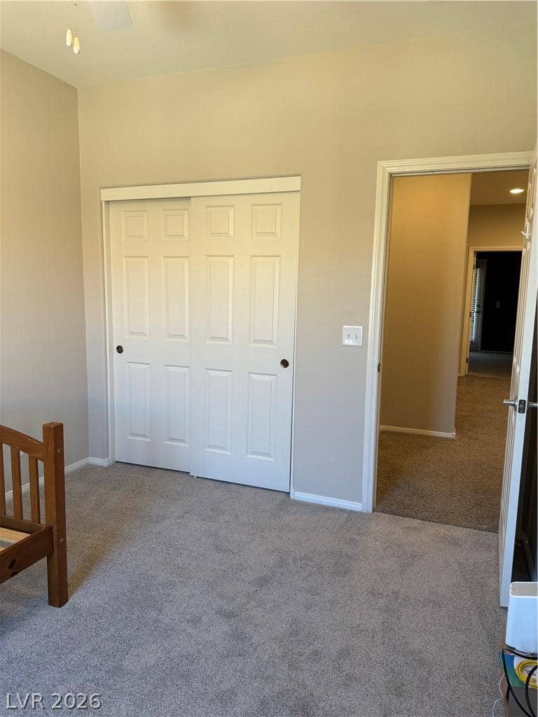 Soft carpeting underfoot enhances this comfortable bedroom with a sliding closet door.