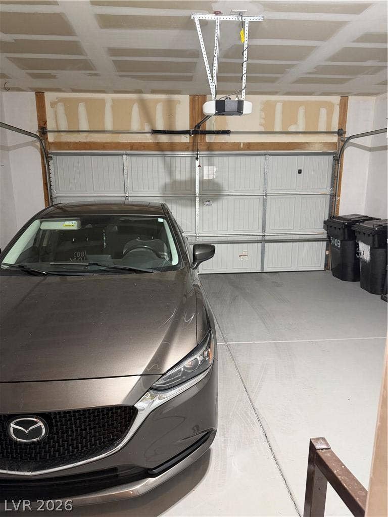 An integrated garage features a smooth concrete floor and an automatic door overhead opener.