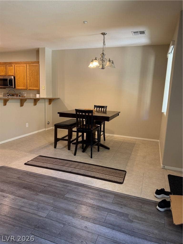 A casual dining space links tiled flooring seamlessly with the adjacent wood-look plank floors.