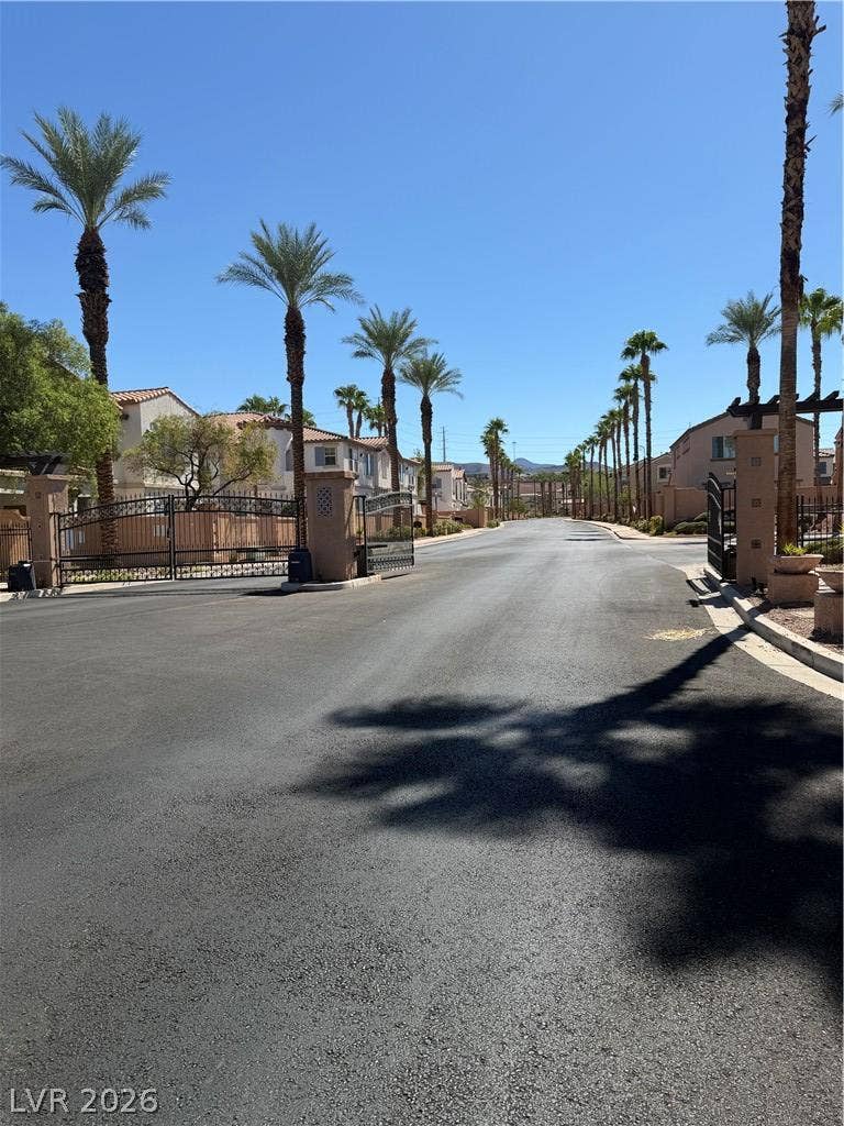 Palm trees line the gated entry of this serene, sun-drenched suburban neighborhood.