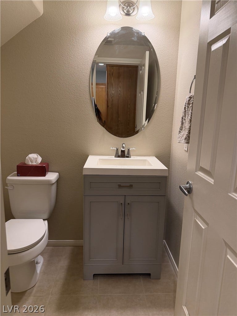 A classic vanity and neutral flooring define this neat powder room.