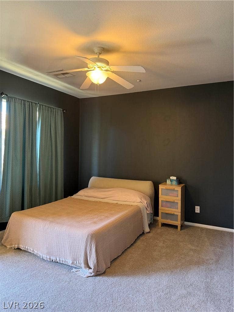 Crown molding and soft carpeting elevate this cozy bedroom retreat.