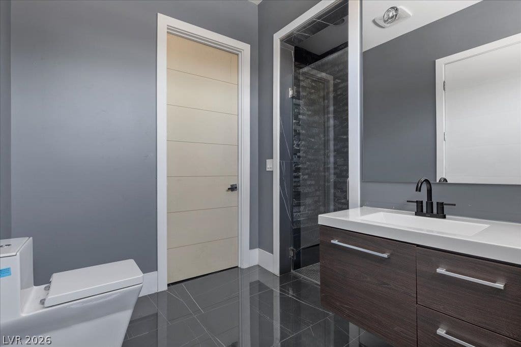2839 Edgemont Drive, Henderson, NV 89074 A sleek vanity with a modern sink and a spacious shower highlight this chic bathroom.