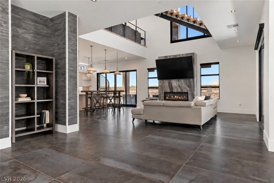 2839 Edgemont Drive, Henderson, NV 89074 A modern fireplace anchors the soaring great room highlighted by large tile floors and elevated ceilings.