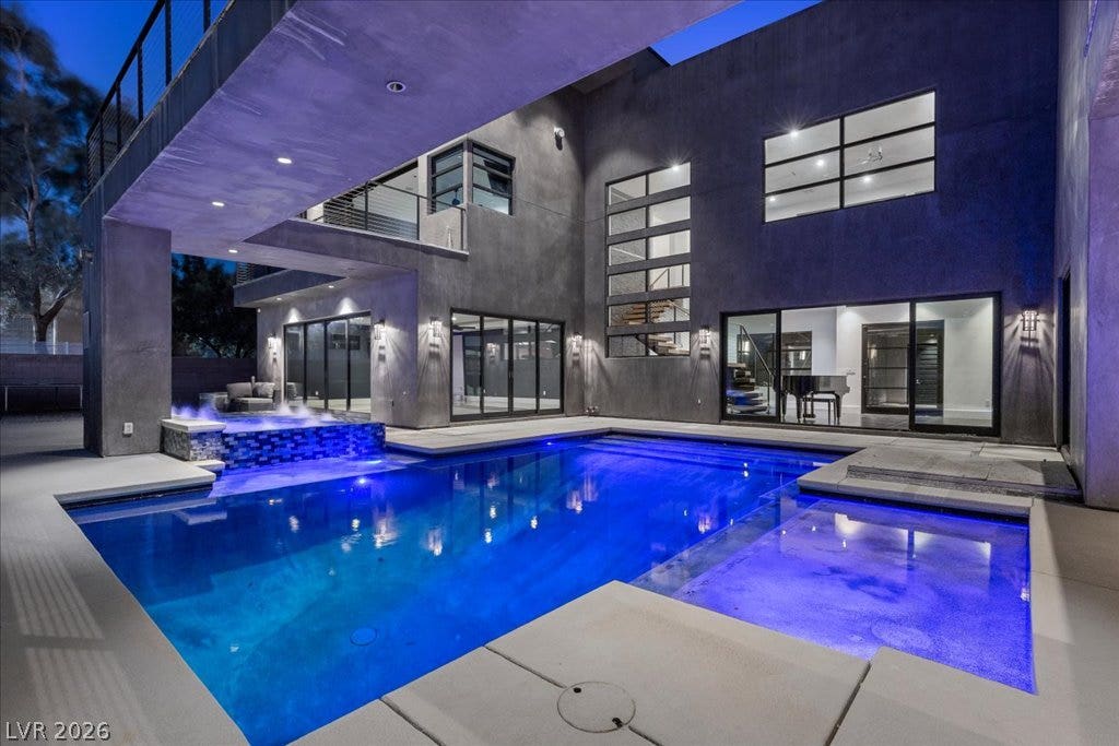 2839 Edgemont Drive, Henderson, NV 89074 An illuminated modern pool and spa offer a striking outdoor oasis against a contemporary architectural backdrop.