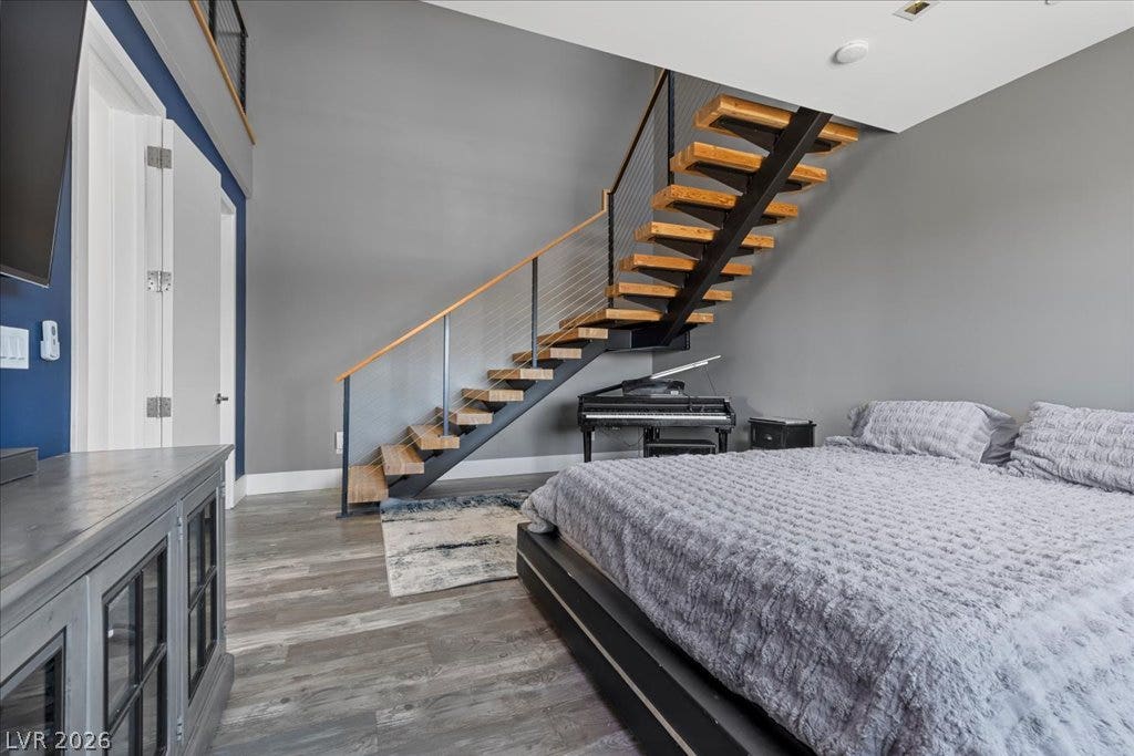 2839 Edgemont Drive, Henderson, NV 89074 A striking modern staircase with rich wood treads anchors this spacious bedroom.