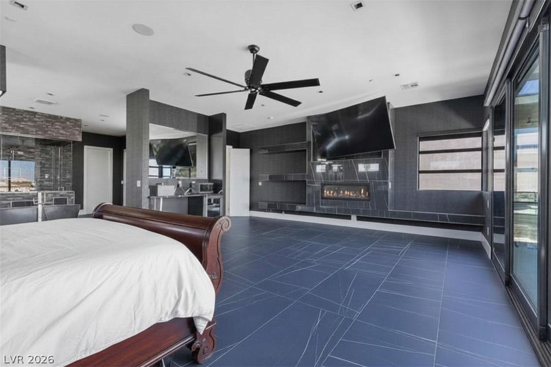2839 Edgemont Drive, Henderson, NV 89074 A striking primary suite with sleek flooring and a contemporary fireplace for elevated comfort.