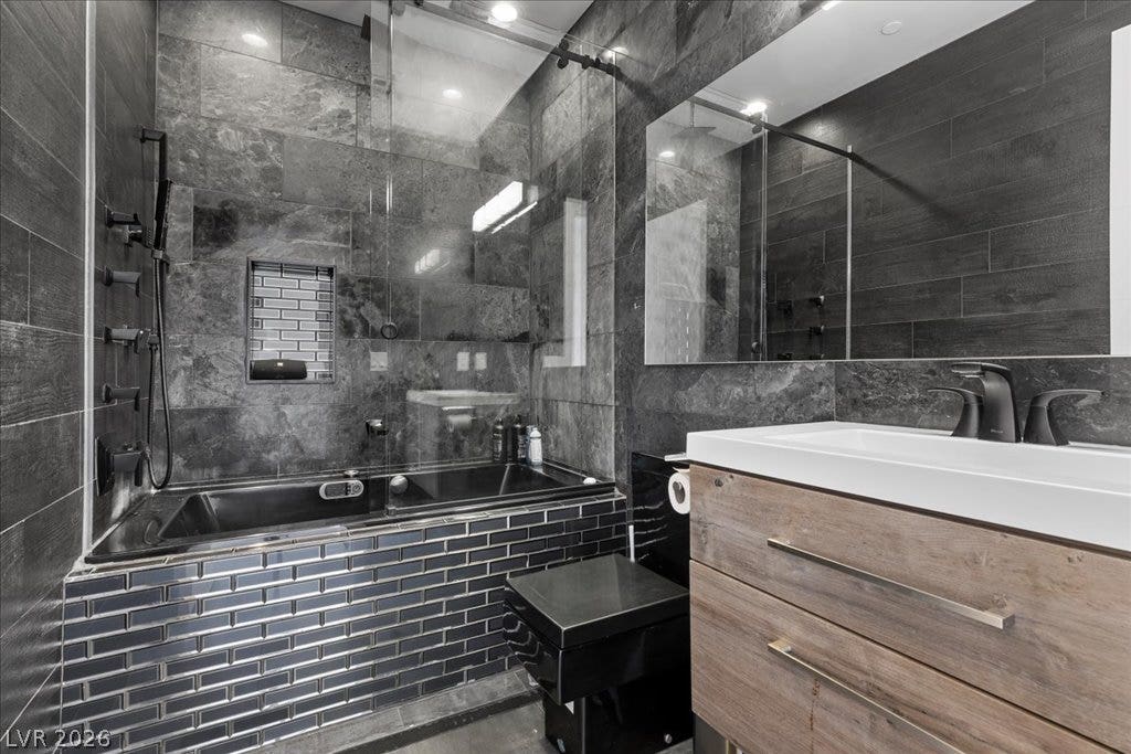 2839 Edgemont Drive, Henderson, NV 89074 Luxurious bathroom showcasing a deep soaking tub and a sleek vanity with modern fixtures.