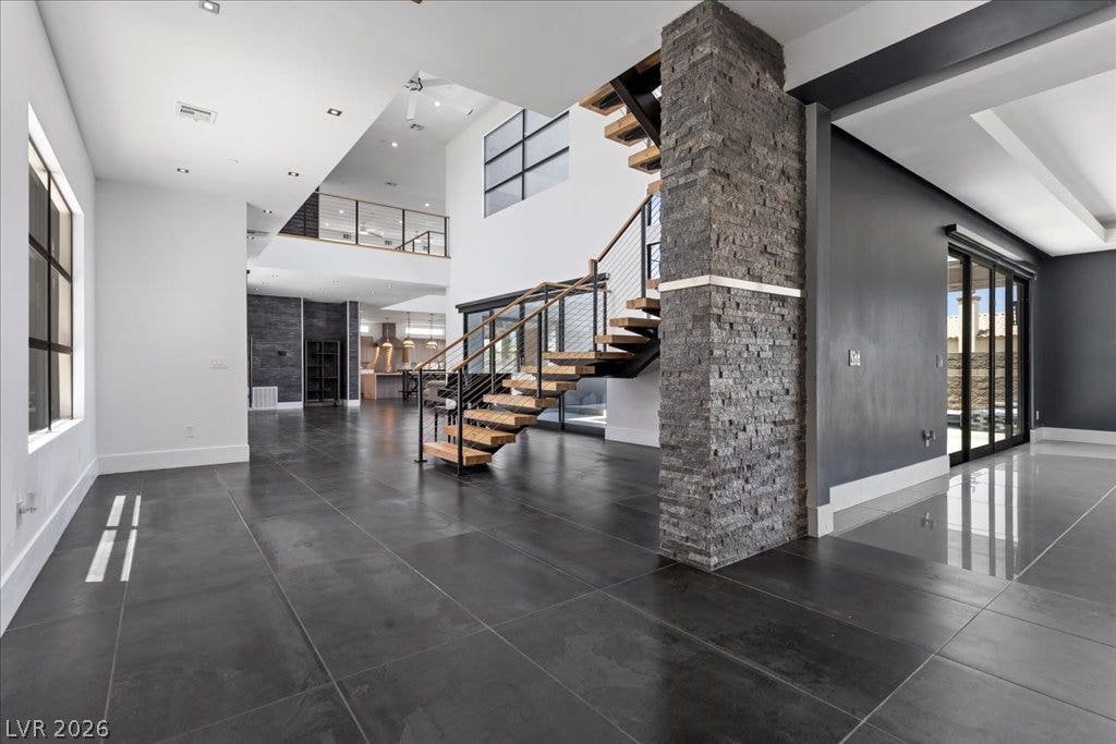 2839 Edgemont Drive, Henderson, NV 89074 A grand entrance welcomes with a floating staircase and an open floorplan, highlighting the home's contemporary elegance.