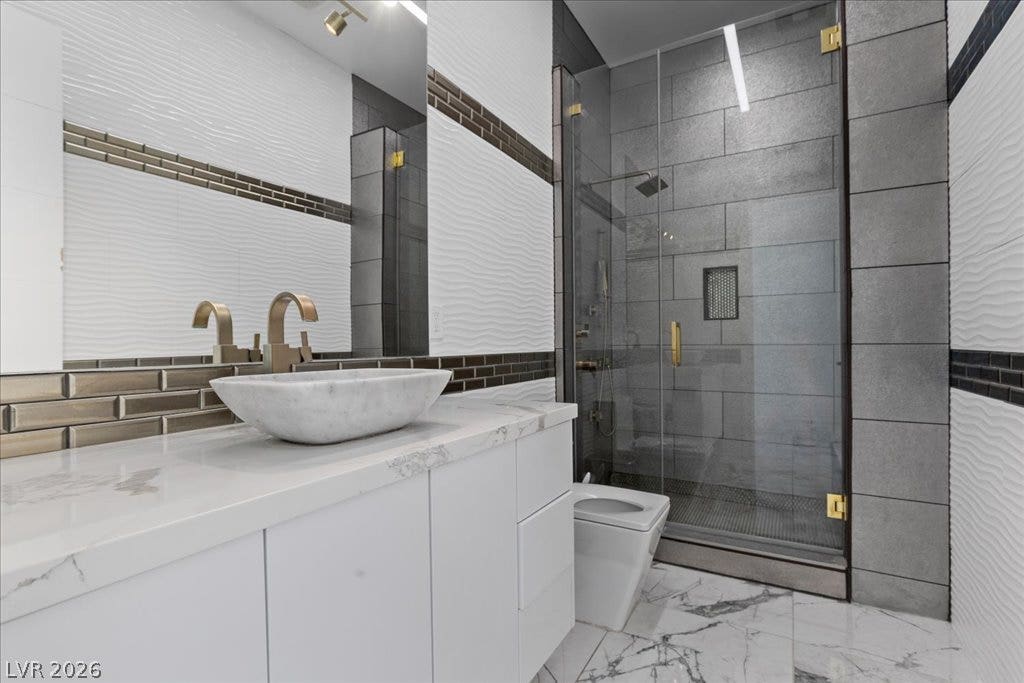 2839 Edgemont Drive, Henderson, NV 89074 Luxurious bathroom showcasing a marble vessel sink and a spacious glass-enclosed shower.