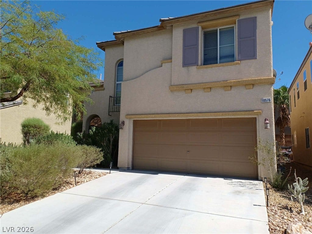 10576 Verona Wood Street, Las Vegas, NV 89141 Desert landscaping and a concrete driveway lead to a two-story home with stucco siding.