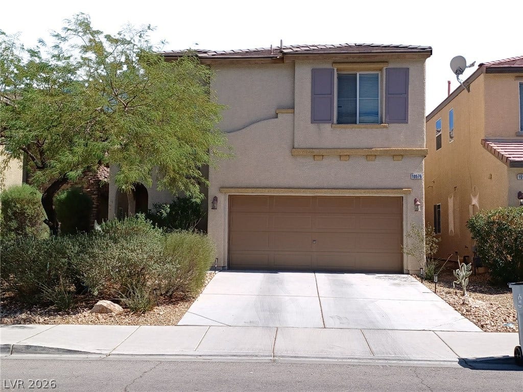 10576 Verona Wood Street, Las Vegas, NV 89141 A stucco exterior with shutter accents frames the private concrete driveway.