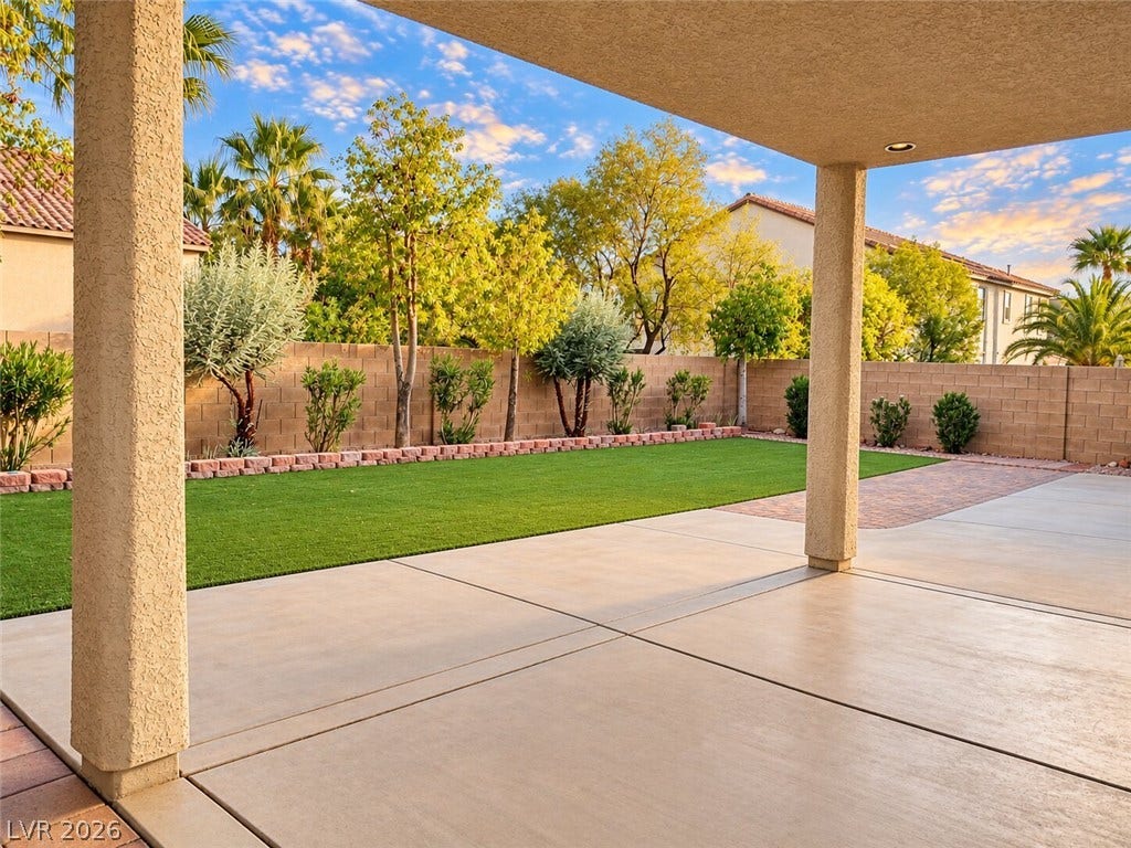 669 Doubleshot Lane, Henderson, NV 89052 An expansive covered concrete patio looks out over a manicured green lawn and perimeter gardens.