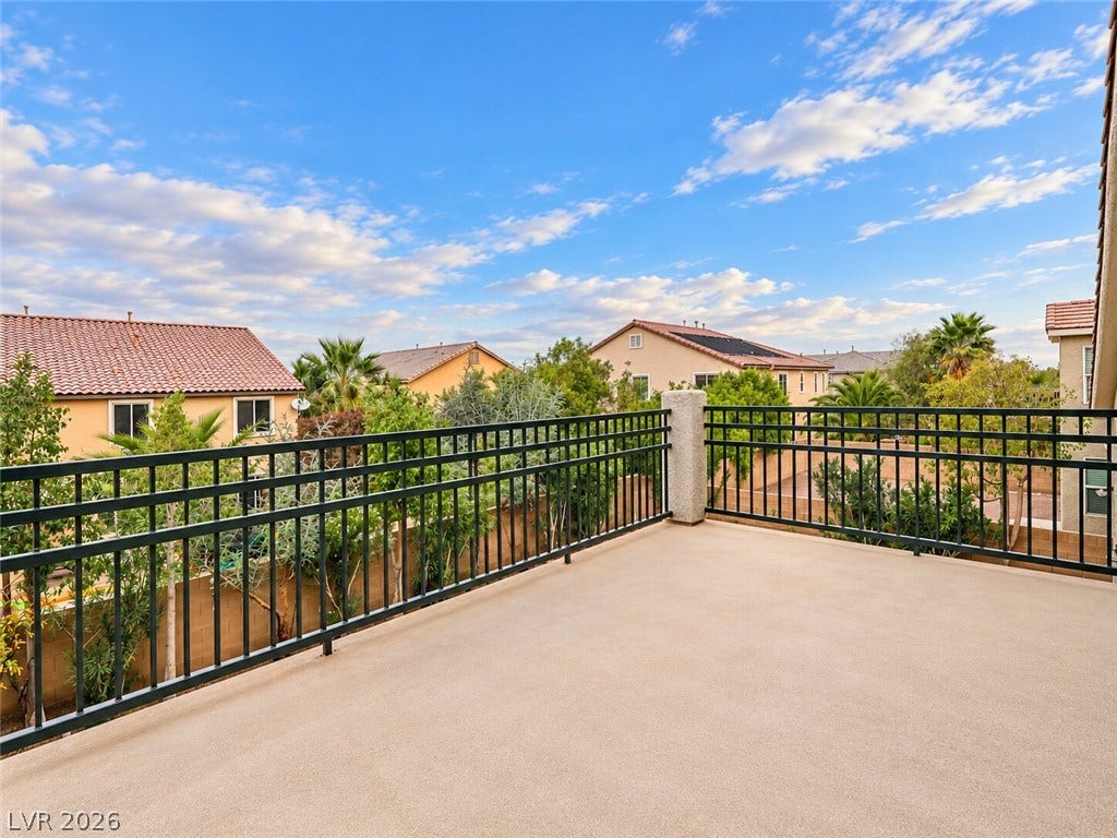 669 Doubleshot Lane, Henderson, NV 89052 A spacious concrete balcony with metal railings looks out over a quiet residential neighborhood.