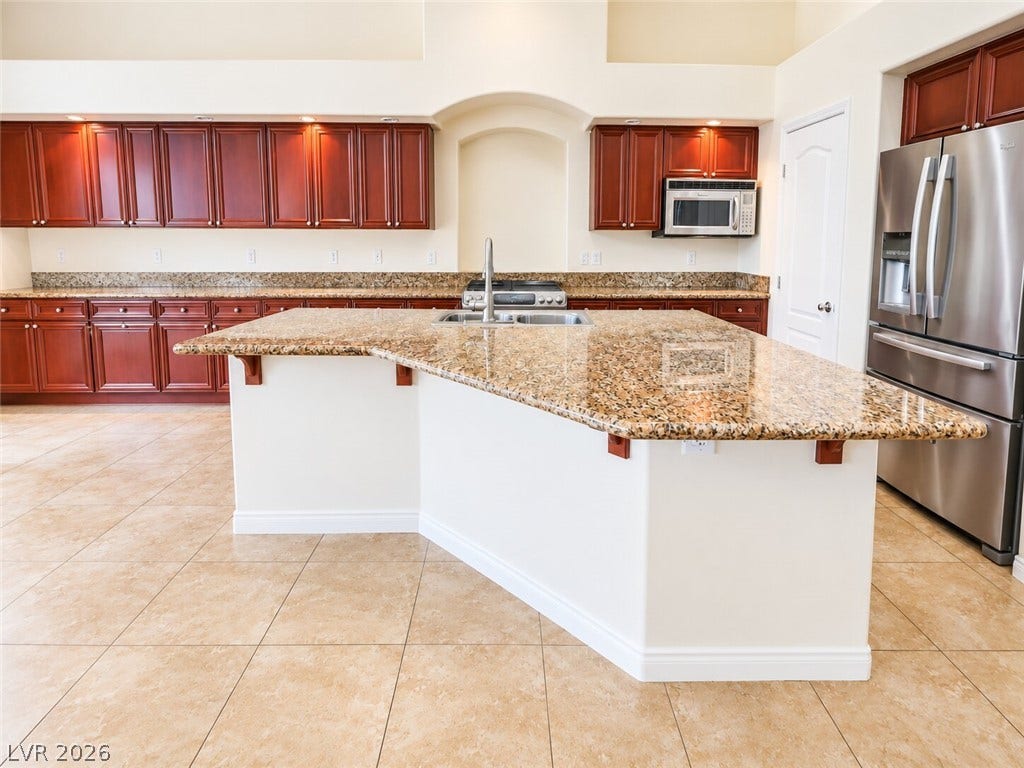 669 Doubleshot Lane, Henderson, NV 89052 Granite countertops and cherry wood cabinetry highlight this culinary space with tile flooring.