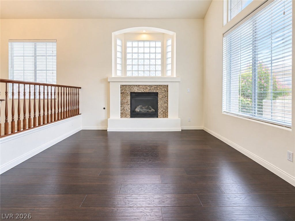 669 Doubleshot Lane, Henderson, NV 89052 Rich dark wood flooring complements a central tiled fireplace below high architectural ceilings.