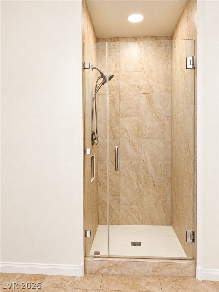 669 Doubleshot Lane, Henderson, NV 89052 A glass-enclosed walk-in shower features neutral tile walls and a built-in recessed niche.