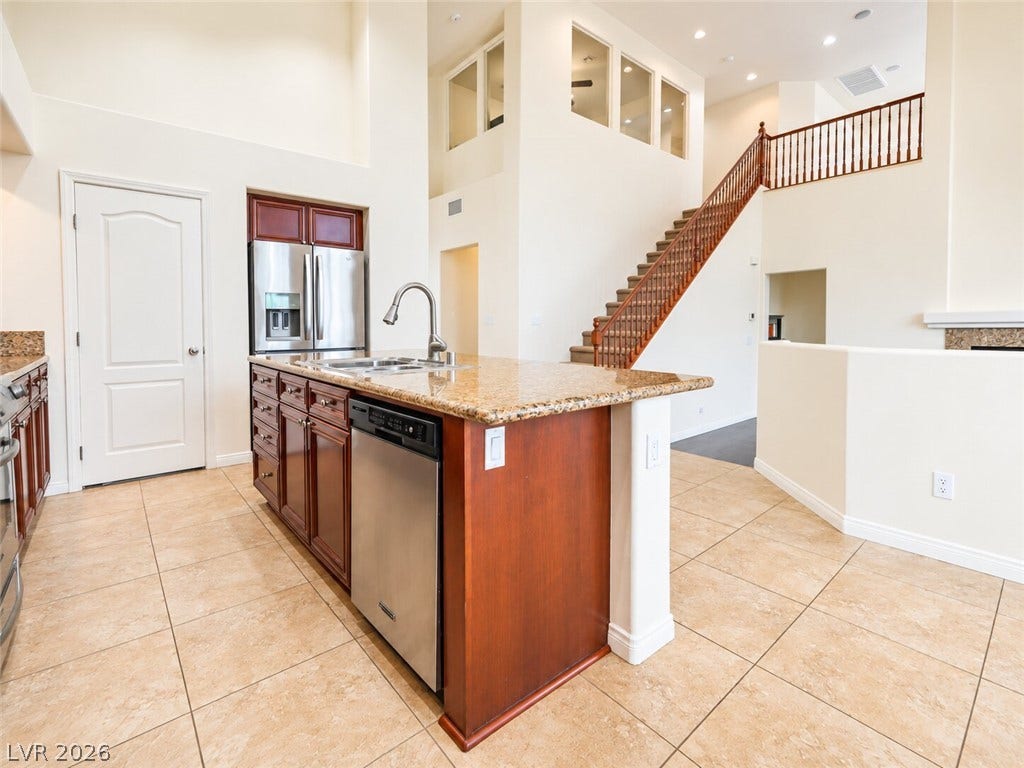 669 Doubleshot Lane, Henderson, NV 89052 An open floorplan seamlessly connects the stone-countertop kitchen island to the soaring staircase.