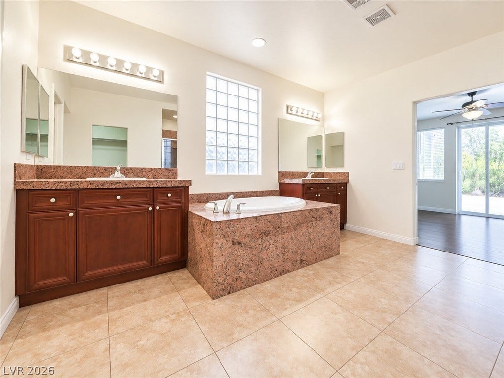 669 Doubleshot Lane, Henderson, NV 89052 Granite counters and tile floors elevate this spacious master bathroom layout.