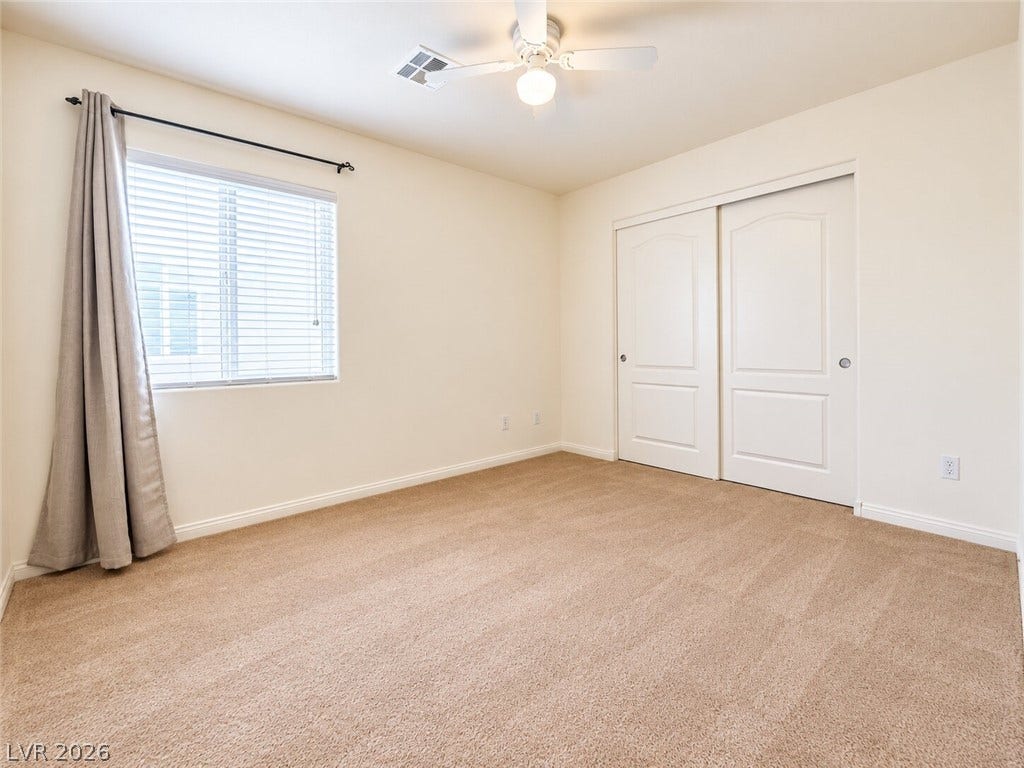 669 Doubleshot Lane, Henderson, NV 89052 A spacious bedroom offers plush carpeting, a large sliding closet, and abundant natural light.