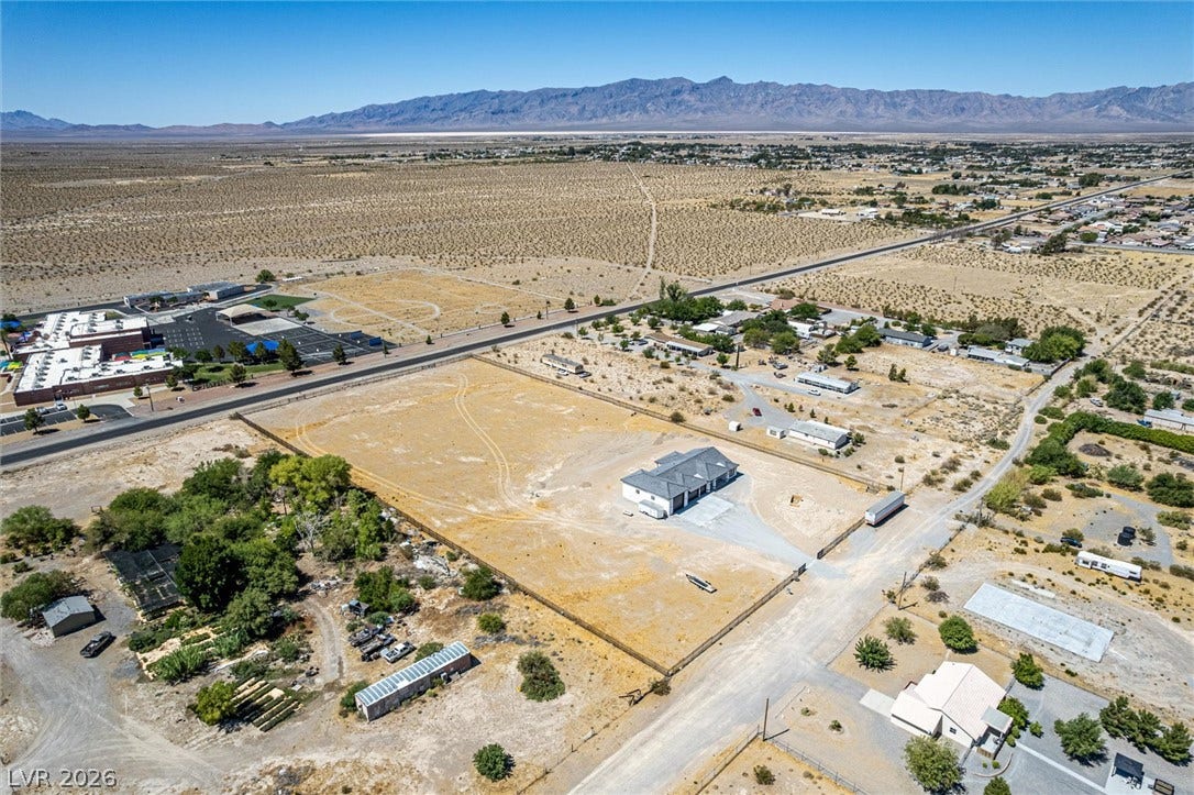 5910 E Kellogg Road, Pahrump, NV 89061 A spacious desert acreage features a gated perimeter fence and expansive mountain views.