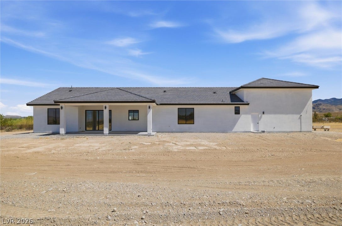5910 E Kellogg Road, Pahrump, NV 89061 Clean lines and a spacious covered patio define the rear exterior of this modern home.