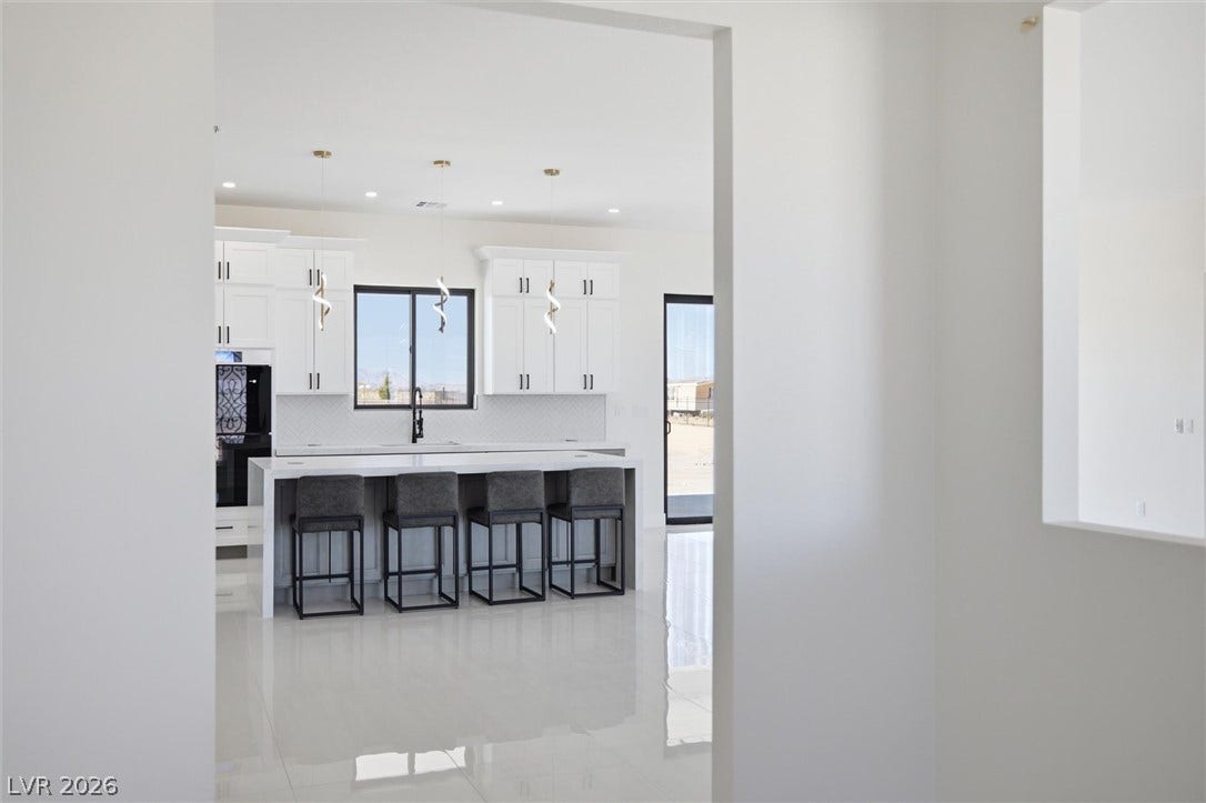 5910 E Kellogg Road, Pahrump, NV 89061 Gleaming polished tile floors reflect light in an open, airy modern kitchen design.