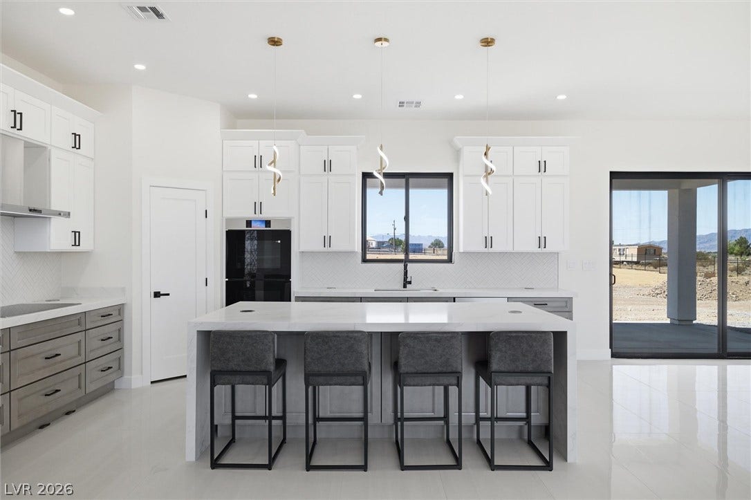 5910 E Kellogg Road, Pahrump, NV 89061 An expansive central island grounds this contemporary culinary space flanked by custom cabinetry and tile flooring.