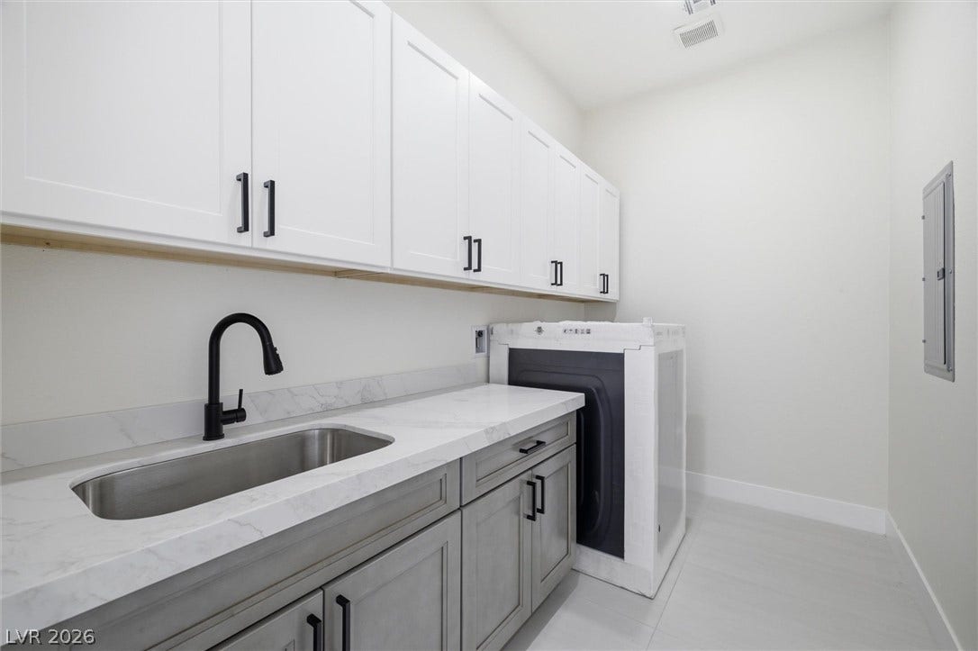 5910 E Kellogg Road, Pahrump, NV 89061 Ample shaker cabinetry and stone countertops elevate this highly functional utility space.