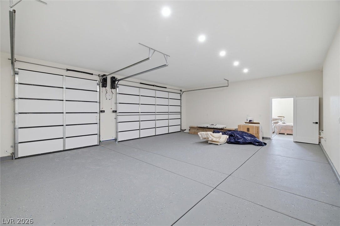 5910 E Kellogg Road, Pahrump, NV 89061 A spacious garage includes durable epoxy flooring, recessed lighting, and multiple overhead doors.