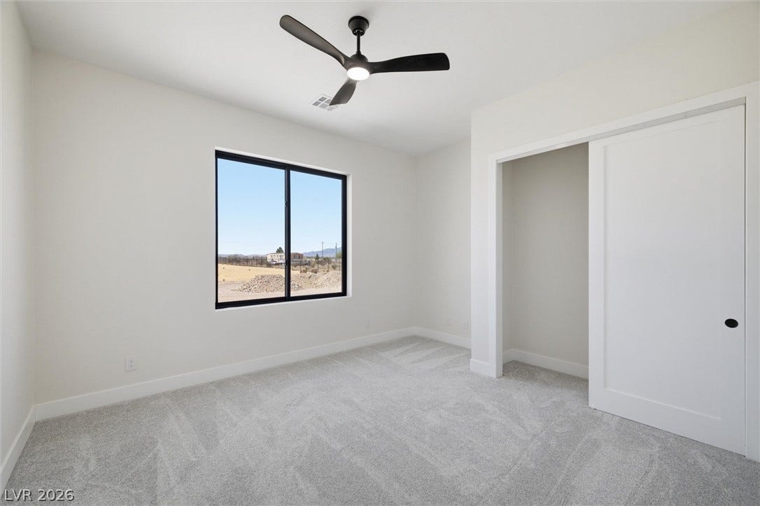 5910 E Kellogg Road, Pahrump, NV 89061 Plush carpeting and a large window frame open desert views in this bedroom.