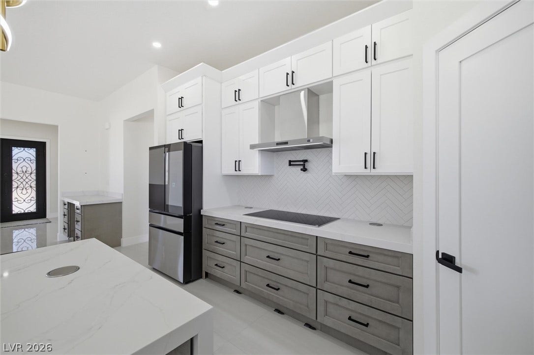 5910 E Kellogg Road, Pahrump, NV 89061 Clean lines and a herringbone tile backsplash define this modern kitchen with ample cabinetry.
