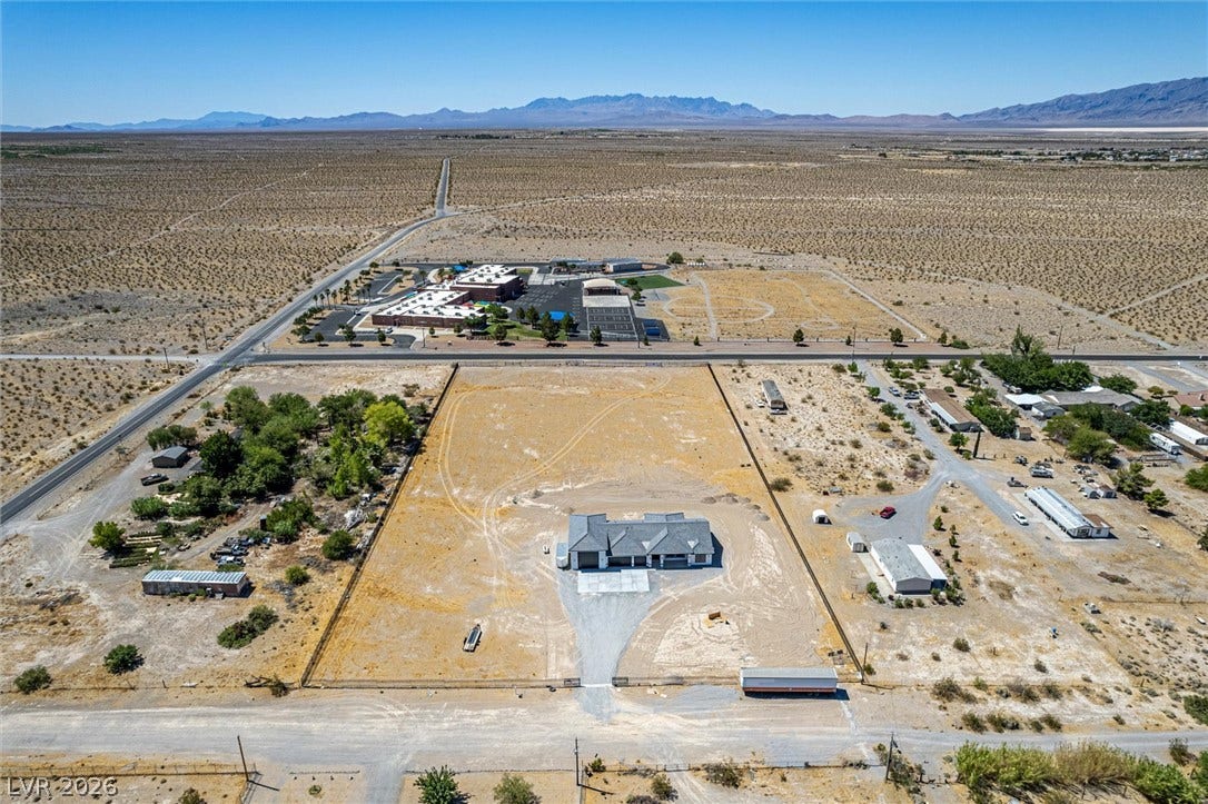 5910 E Kellogg Road, Pahrump, NV 89061 An expansive desert lot surrounds the home against a backdrop of distant mountains.