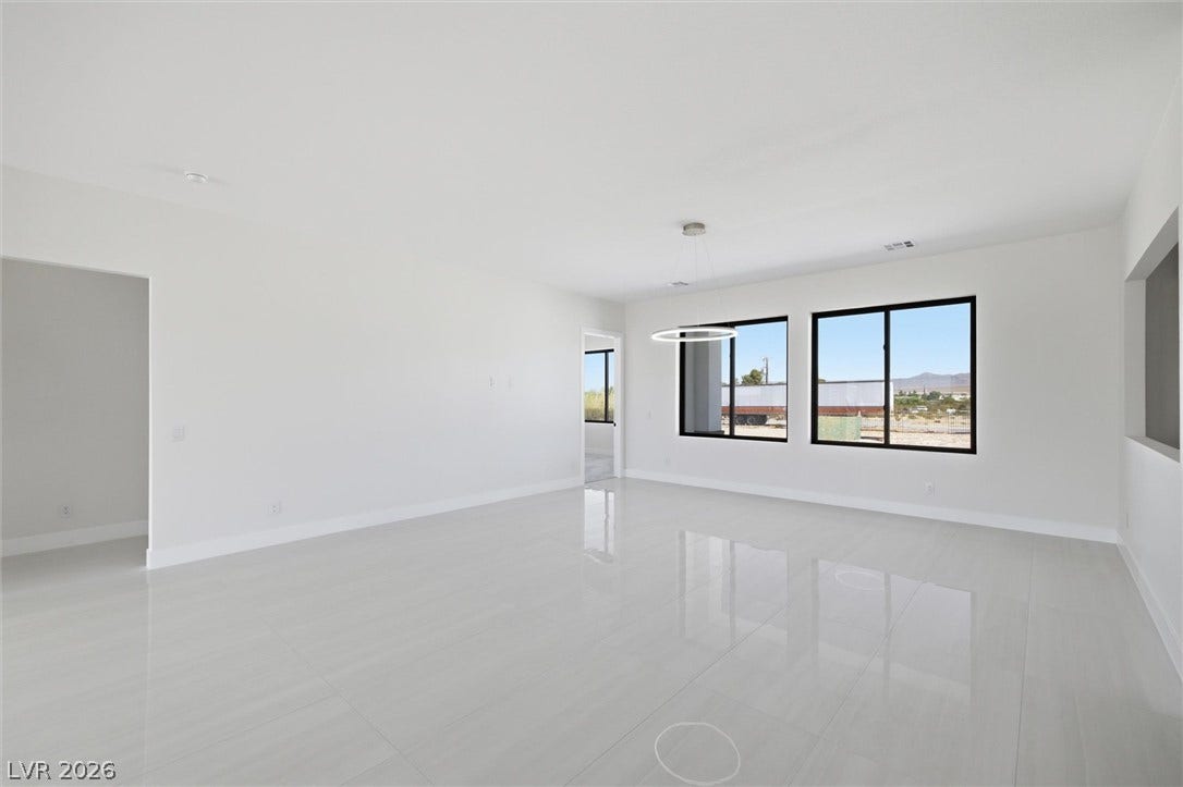 5910 E Kellogg Road, Pahrump, NV 89061 Gleaming polished tile floors and expansive windows define this minimalist open-concept living space.
