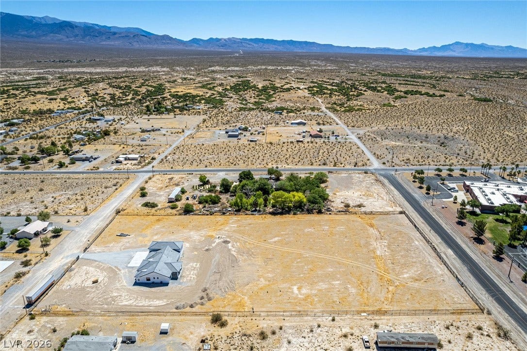 5910 E Kellogg Road, Pahrump, NV 89061 An expansive desert lot under blue skies with distant mountain ranges bordering the horizon.