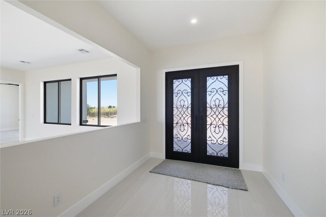 5910 E Kellogg Road, Pahrump, NV 89061 Double entry doors with intricate glasswork open into a polished, high-ceilinged foyer.