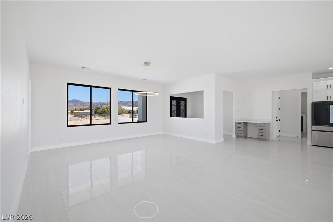 5910 E Kellogg Road, Pahrump, NV 89061 Polished tile flooring and black-framed windows define this spacious, open-concept living area.