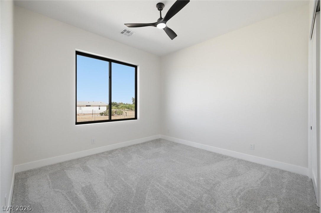 5910 E Kellogg Road, Pahrump, NV 89061 Plush carpeting and a large window framing neighborhood views define this tranquil space.
