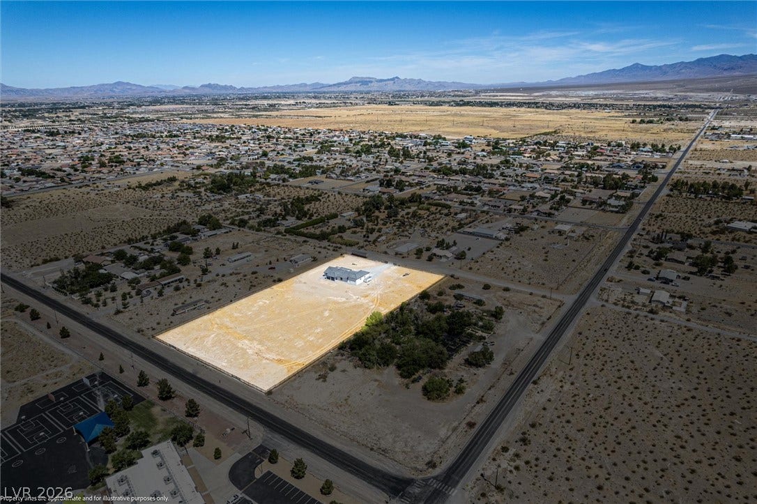 5910 E Kellogg Road, Pahrump, NV 89061 Aerial perspectives reveal an expansive desert lot with a single residential structure surrounded by mountain views.