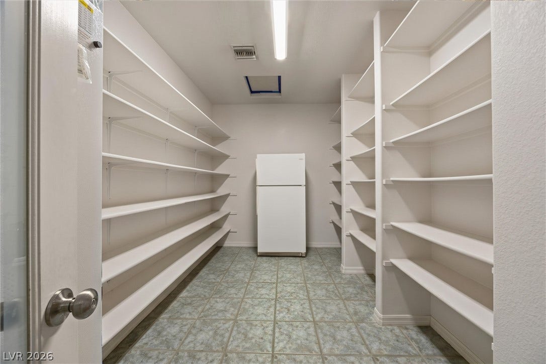 211 W Highland Drive, Henderson, NV 89015 Large walk in pantry with reach through to kitchen side. AI generatored to remove pantry items.