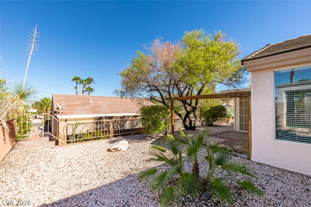 Low-maintenance desert landscaping frames the home's rear exterior under clear desert skies.