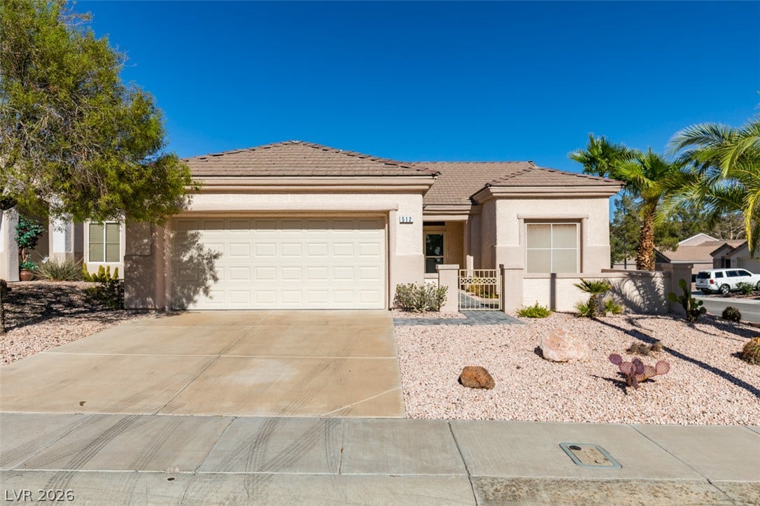 A classic stucco exterior, tile roof, and desert landscaping define this inviting one-story home.