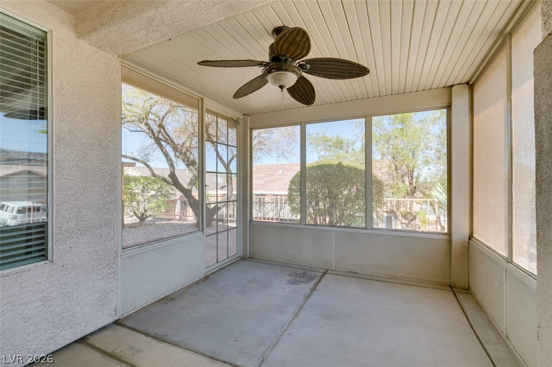 Concrete flooring and large windows define this enclosed outdoor living area.