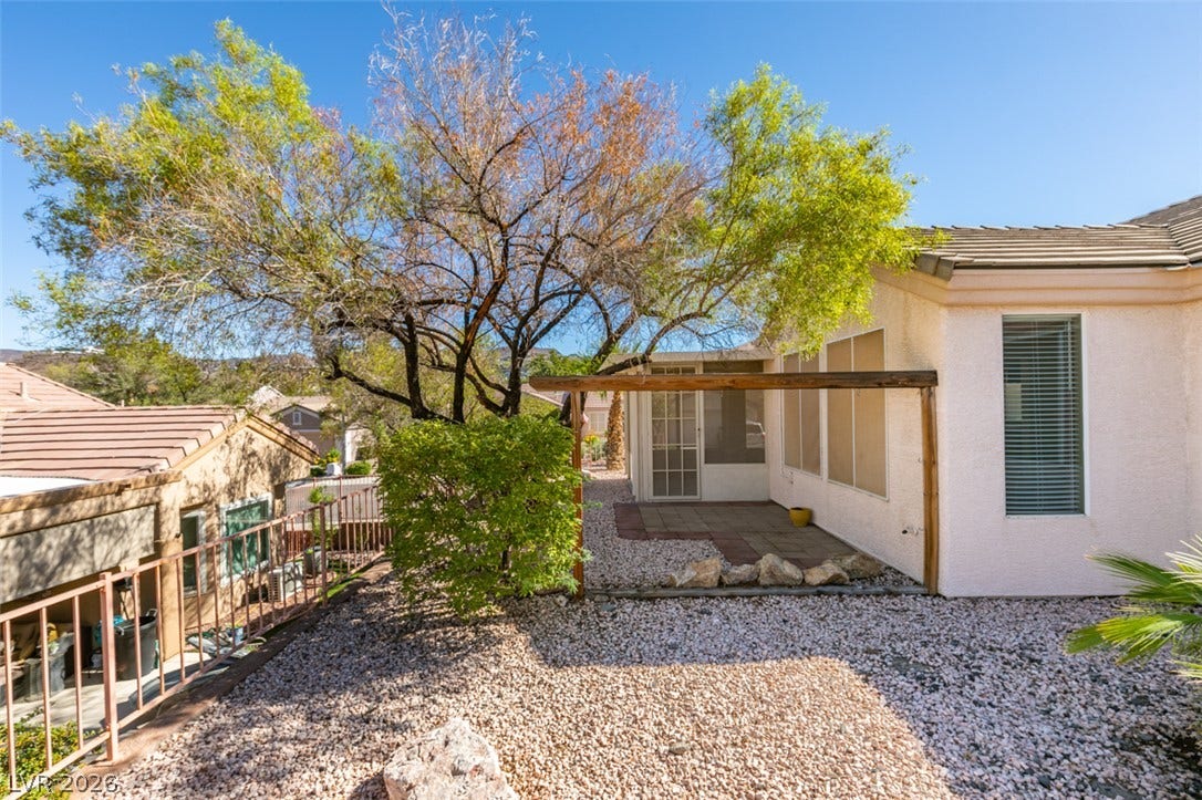 Mature shade trees and low-maintenance desert landscaping frame the private outdoor patio.
