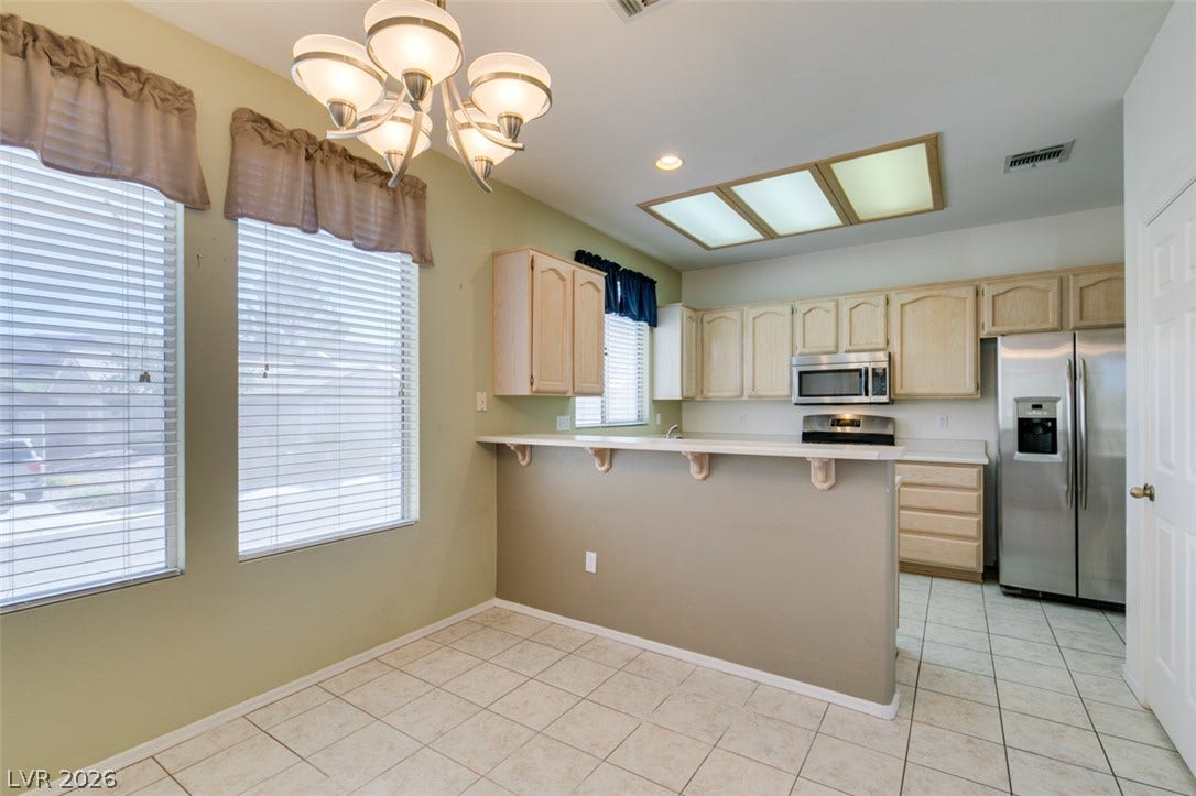 Tile flooring and classic cabinetry define this functional kitchen and dining space.