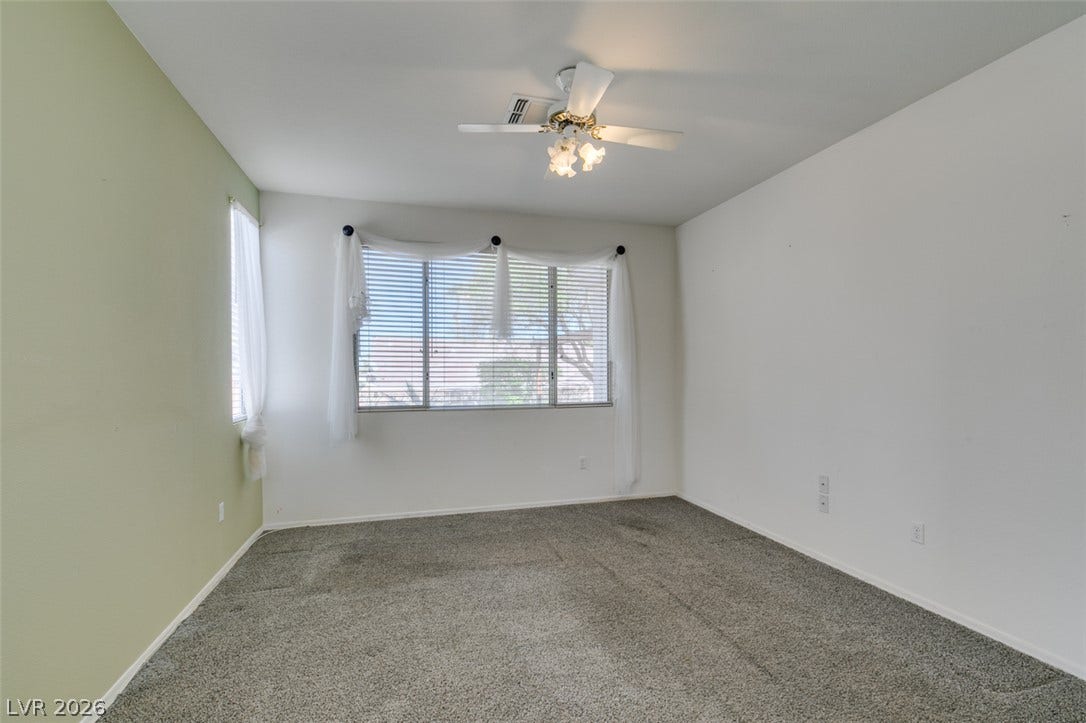 Plentiful natural light fills a versatile bedroom space featuring soft wall-to-wall carpeting.