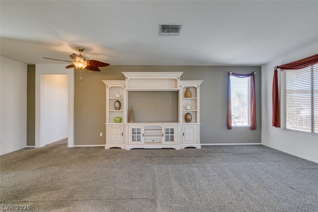 Plush carpeting anchors this comfortable living area featuring a large built-in media center.